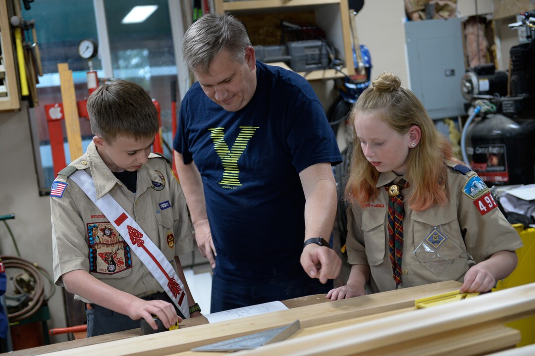 (Francisco Kjolseth  |  The Salt Lake Tribune)  Darwin Cook, Deseret Peak District Chair with the Boy Scouts of America offers guidance to her son Kolbie, 12, as he works on his Eagle Scout project with help from his sister Miriam, 11, in the family garage in Tooele on Monday, May 14, 2018. Miriam is an early adopter into the Cub Scouts, always having expressed an interest in what her brother is doing.