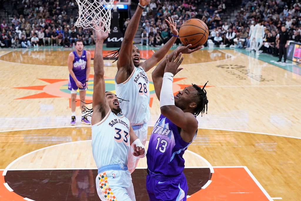 Utah Jazz guard Isaiah Collier (13) drives to the basket against San Antonio Spurs guard Tre Jones (33) during the second half of an NBA basketball game in San Antonio, Thursday, Nov. 21, 2024. (AP Photo/Eric Gay)