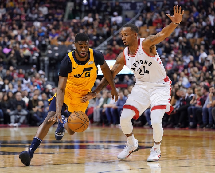 Utah Jazz's Emmanuel Mudiay (8) drives to the basket as Toronto Raptors' Norman Powell (24) defends during first half NBA basketball action in Toronto, Sunday, Dec. 1, 2019. (Hans Deryk/The Canadian Press via AP)