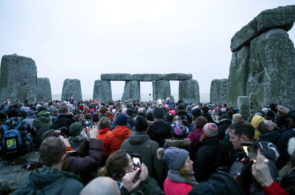 People gather at Stonehenge in Wiltshire, western England, on the winter solstice to witness the sunrise after the longest night of the year Friday Dec. 22, 2017. (Andrew Matthews/PA via AP)
