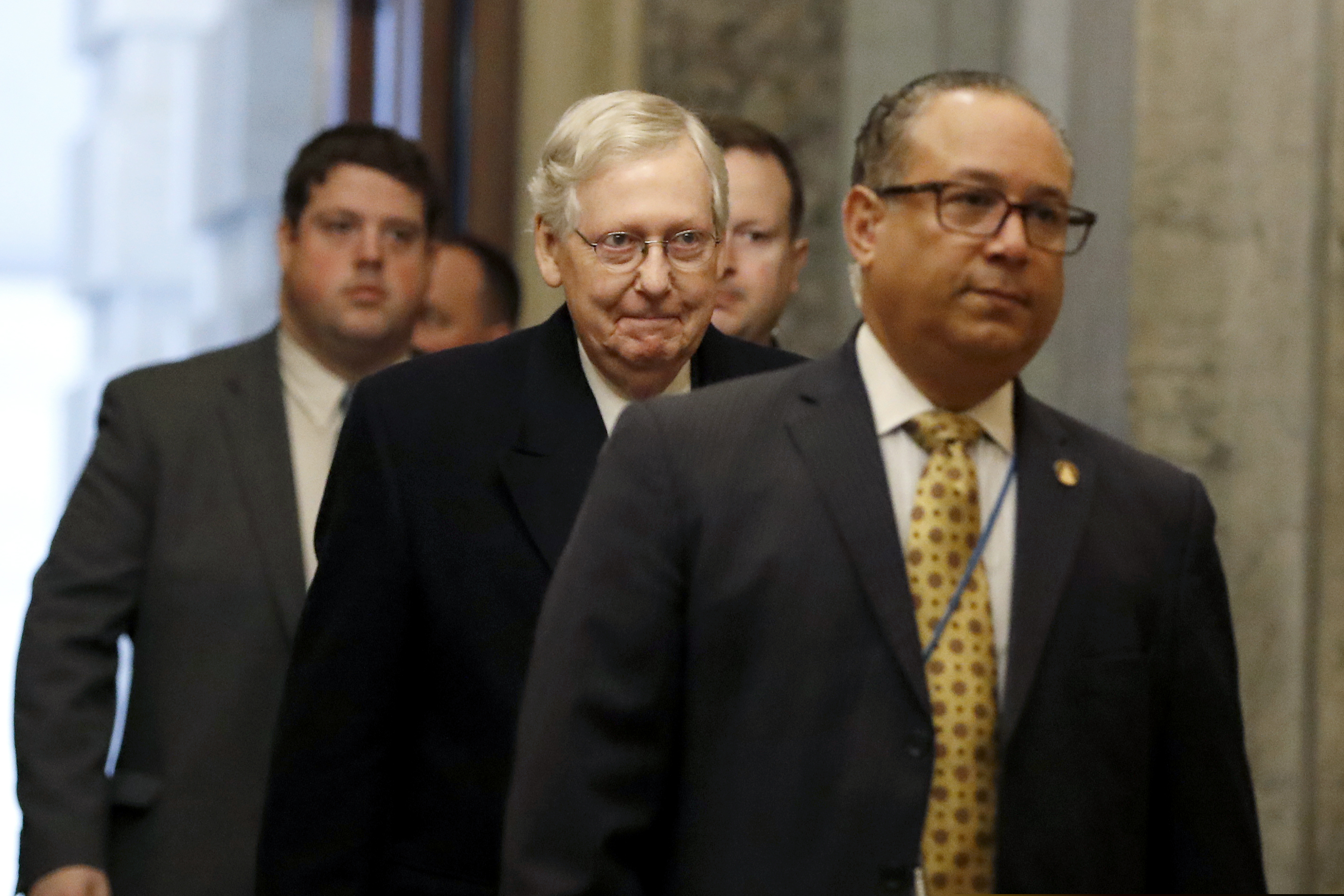 (Julio Cortez | AP) Senate Majority Leader Mitch McConnell of Ky., center, arrives at the Capitol in Washington during the impeachment trial of President Donald Trump on charges of abuse of power and obstruction of Congress, Friday, Jan. 24, 2020.