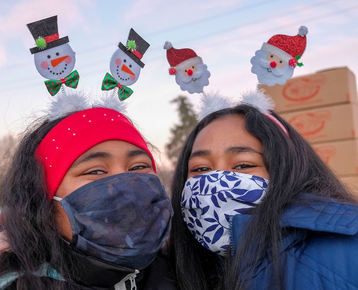 (Leah Hogsten | The Salt Lake Tribune) Volunteer sisters Maryan Vatuvei, 11, and her sister Eime Vatuvei, 12, help hand out food from the Utah Food Bank to needy families, Dec. 23, 2020.