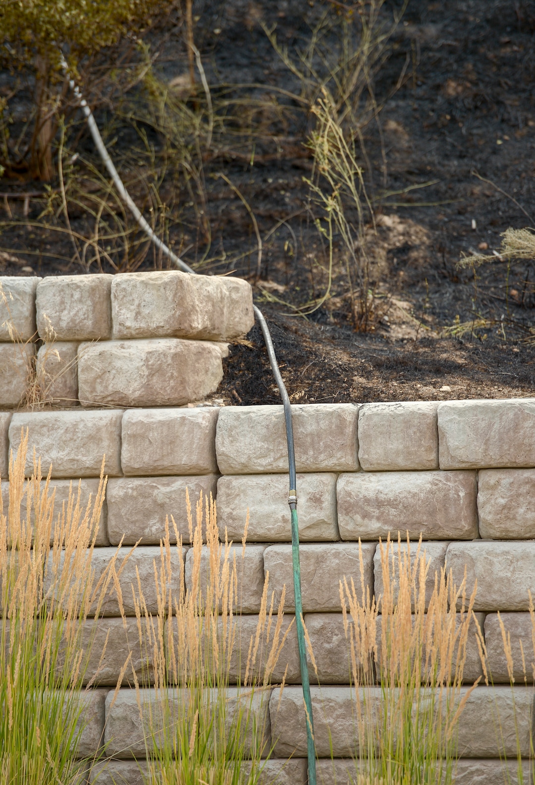 Leah Hogsten  |  The Salt Lake Tribune  Garden hoses were the first line of defense for residents of Columbus Court trying to fight Tuesday's grass fire. Five people were injured and one home was damaged by a fast-moving grass fire on Columbus Court, Tuesday, July 24, 2018. Forty homes were evacuated as flames spread through about 100 acres. Between 50 and 60 firefighters responded to the fire.