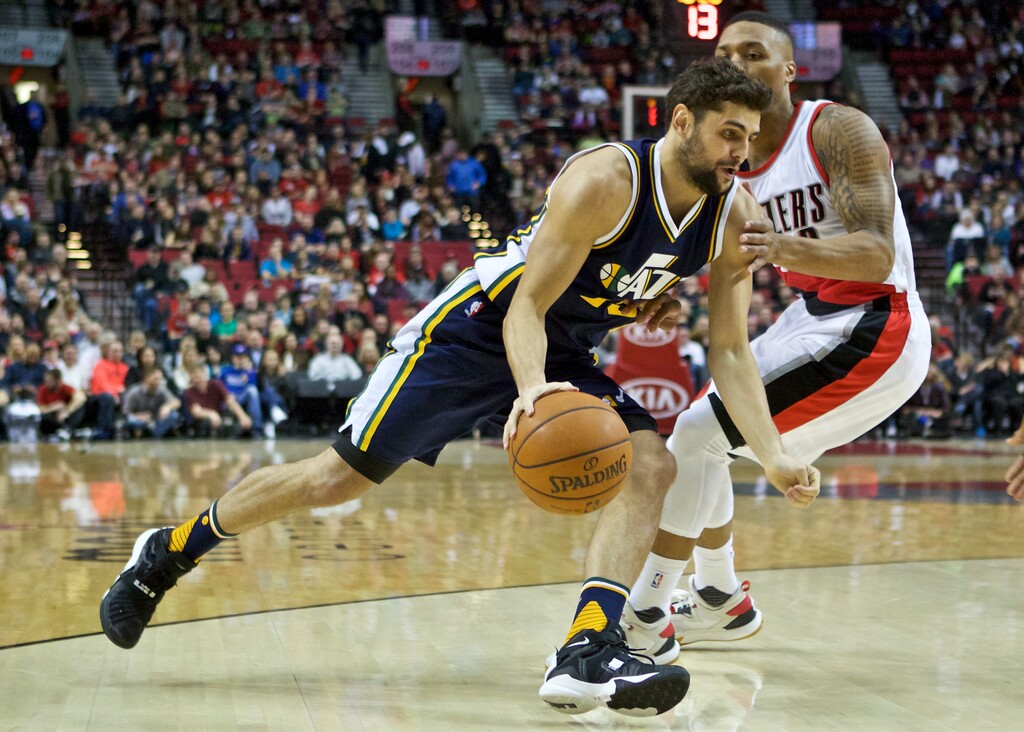 Utah Jazz guard Raul Neto, left, dribbles past Portland Trail Blazers guard Damian Lillard, right, during the first half of an NBA basketball game in Portland, Ore., Wednesday, Jan. 13, 2016. (AP Photo/Craig Mitchelldyer)