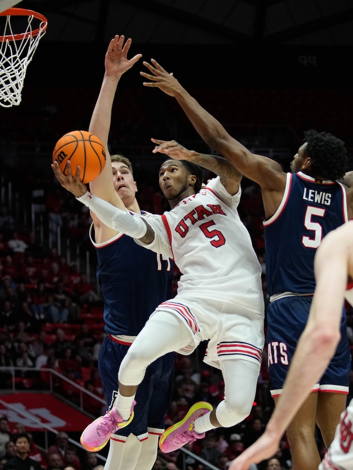 (Francisco Kjolseth  |  The Salt Lake Tribune) Utah Utes guard Deivon Smith (5) pushes past Arizona Wildcats center Motiejus Krivas (14) and Arizona Wildcats guard KJ Lewis (5) in PAC-12 basketball action between the Utah Utes and the Arizona Wildcats at the Jon M. Huntsman Center, on Thursday, Feb. 8, 2024.