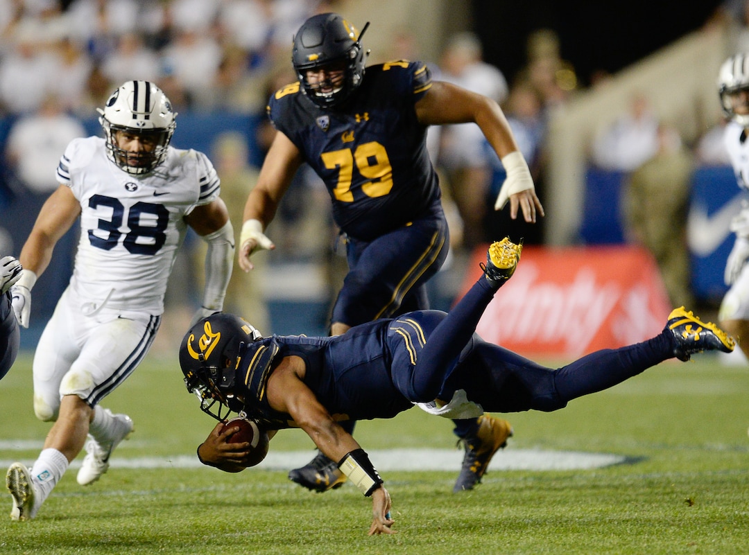 (Francisco Kjolseth  |  The Salt Lake Tribune)  California Golden Bears quarterback Brandon McIlwain (5) gets tripped up by BYU during the second half of the NCAA college football game, Saturday, Sept. 8, 2018, at LaVell Edwards stadium in Provo, Utah.