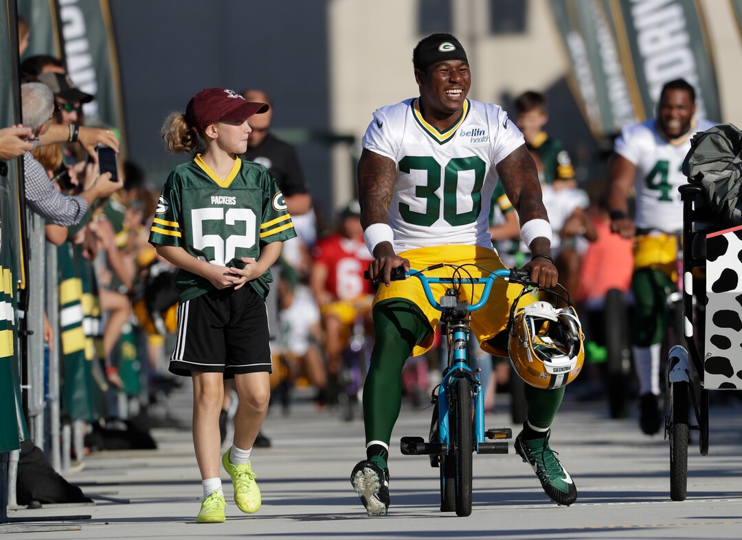 Green Bay Packers' Jamaal Williams rides a bike to NFL football training camp Thursday, July 27, 2017, in Green Bay, Wis. (AP Photo/Morry Gash)
