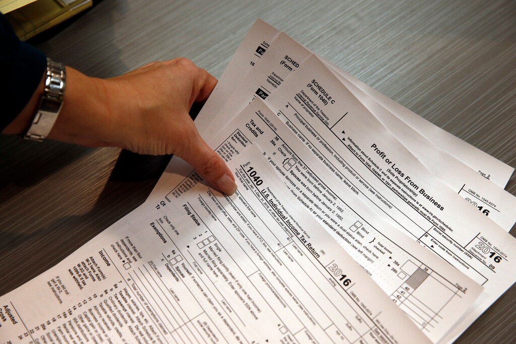 (Brennan Linsley | AP photo)

In this Jan. 14, 2017, photo, tax professional and tax preparation firm owner Alicia Utley reaches for hard copies of tax forms while working to stay caught up at the start of the tax season rush in her offices at Infinite Tax Solutions, in Boulder, Colo.