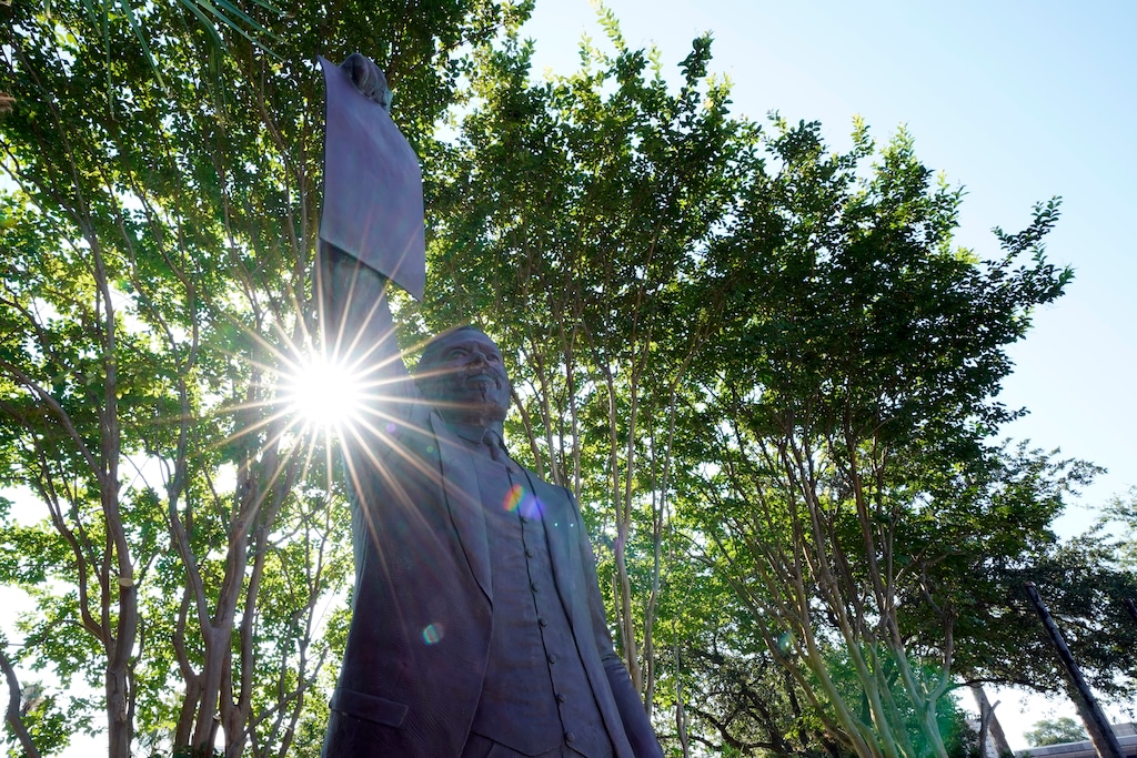 This June 17, 2020, photo, shows a statue depicting a man holding the state law that made Juneteenth a state holiday in Galveston, Texas. The inscription on the statue reads "On June 19, 1865, at the close of the Civil War, U.S. Army General Gordon Granger issued an order in Galveston stating that the 1863 Emancipation Proclamation was in effect. That event, later known as "Juneteenth," marked the end of slavery in Texas. Celebrated as a day of freedom since then, Juneteenth grew into an international commemoration and in 1979 became an official Texas holiday through the efforts of State Representative Albert (AL) Edwards of Houston." (AP Photo/David J. Phillip)