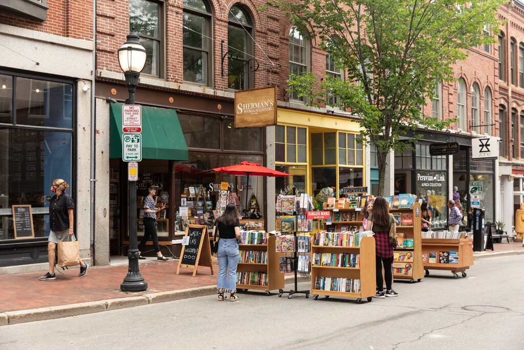 (Greta Rybus | The New York Times) Shoppers on a street, which has become pedestrian-only to accommodate outdoor dining and shopping, in Portland, Maine, on June 23, 2020. Some states and counties are delaying and even reversing reopenings as virus cases mount in the South and West. Experts say more opening and closing could go on for months.