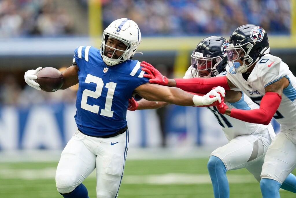 (Michael Conroy | AP) Indianapolis Colts running back Zack Moss (21) runs past Tennessee Titans safety Kevin Byard, center, and cornerback Sean Murphy-Bunting on Sunday.