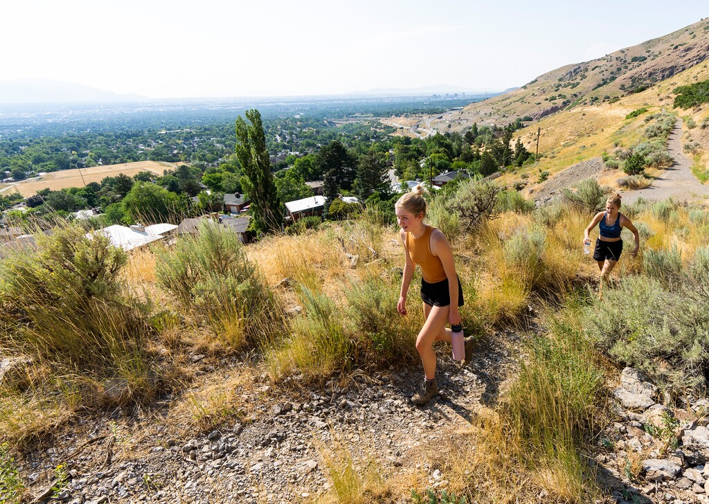 (Rick Egan | The Salt Lake Tribune)  Mira Petersen, and Kaitlyn Kunz hike on Tuesday, Aug. 2, 2022 along one of many social trails that break off of the Grandeur Peak Face Trail, which starts at the north end of Wasatch Boulevard.  A connector trail between that trailhead and the Pipeline Trail in Mill Creek Canyon is slated to be completed by the end of the year. It has been in the works for more than 20 years and will create 10 continuous miles of Bonneville Shoreline Trail.