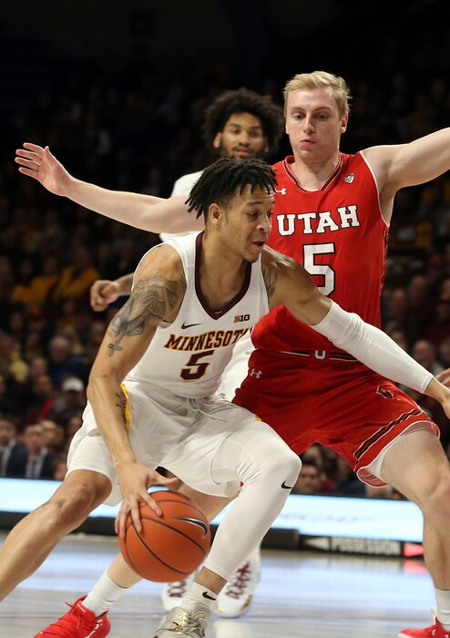 Minnesota's Amir Coffey, left, drives around Utah's Parker Van Dyke in the first half of an NCAA college basketball game Monday, Nov. 12, 2018, in Minneapolis. (AP Photo/Jim Mone)