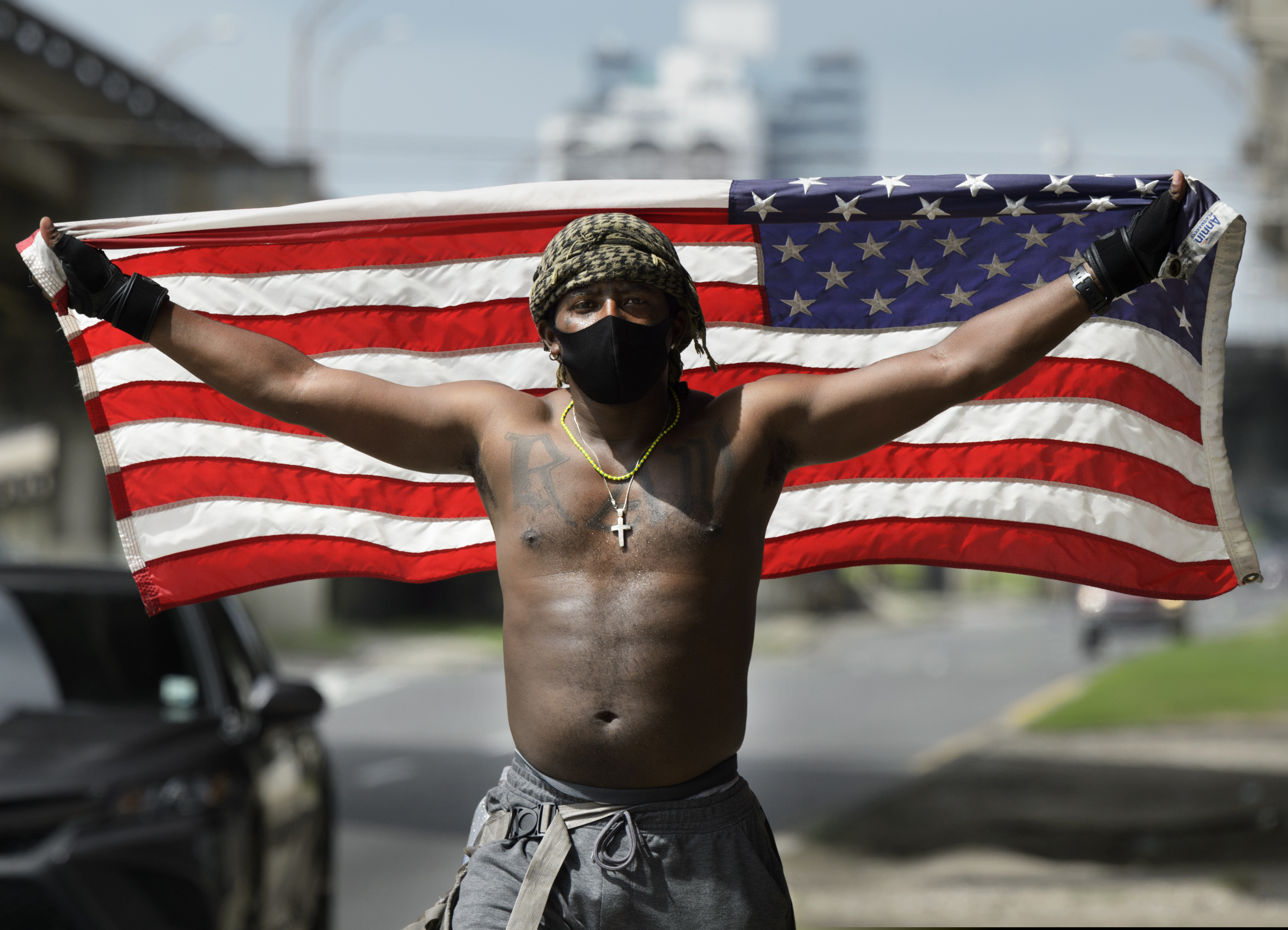 (Max Becherer | The Times-Picayune | The New Orleans Advocate) A protester holds up an American flag as about a dozen people gather on the corner of Esplanade Ave. and N. Claiborne Ave., Friday, May 29, 2020, in New Orleans, La., to protest the death of George Floyd, a handcuffed black man who died in police custody after he pleaded for air as a white police officer kneeled on his neck in Minneapolis.