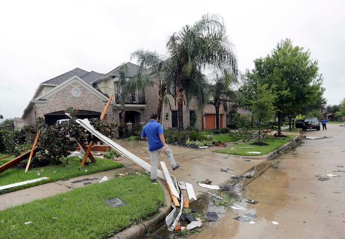 (David J. Phillip | The Associated Press) A contractor walks over debris from Hurricane Harvey Saturday, Aug. 26, 2017, in Missouri City, Texas.  Harvey rolled over the Texas Gulf Coast on Saturday, smashing homes and businesses and lashing the shore with wind and rain so intense that drivers were forced off the road because they could not see in front of them.