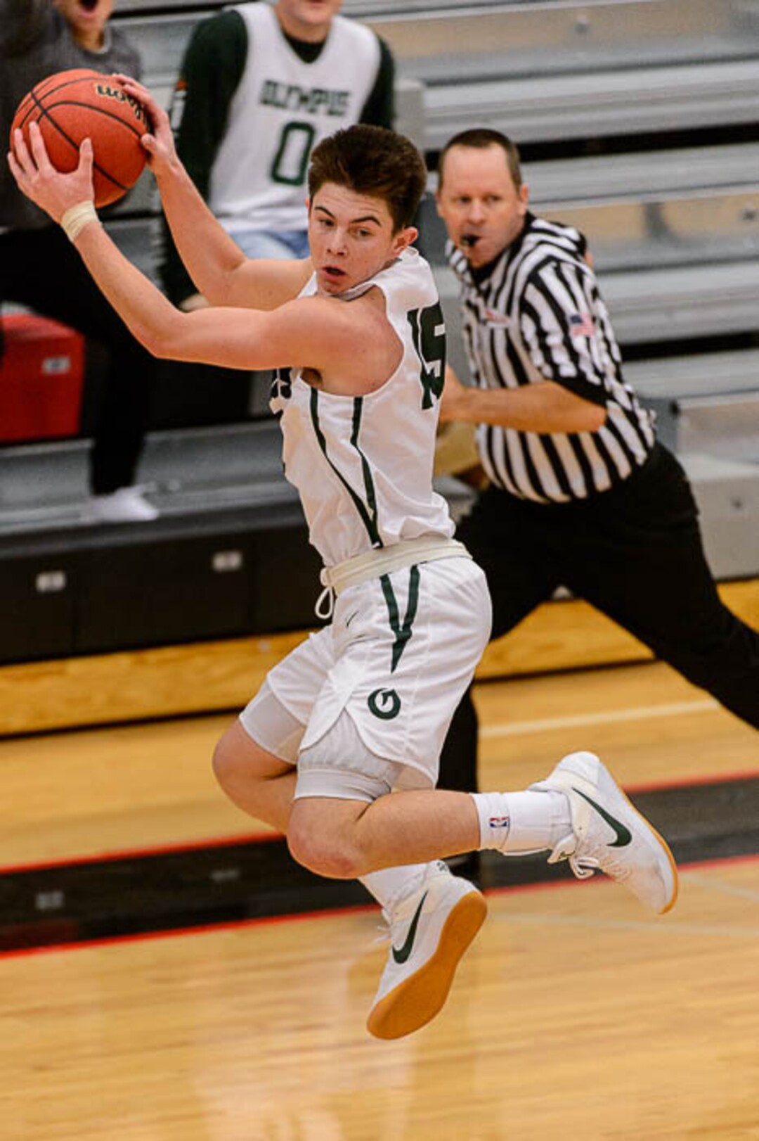 (Trent Nelson | The Salt Lake Tribune)  Olympus's Rylan Jones leaps for a loose ball as Olympus faces Bingham, high school boys' basketball at the Utah Elite 8 tournament in American Fork, Thursday December 7, 2017.