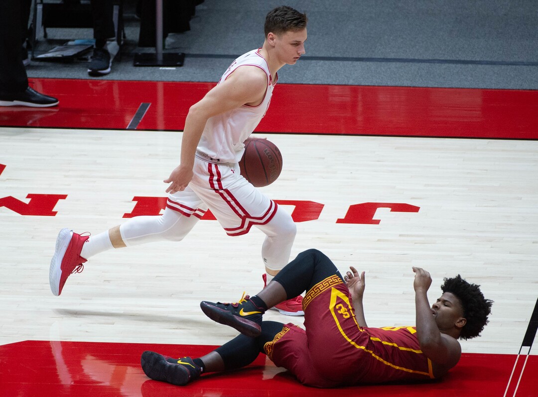 (Francisco Kjolseth  | The Salt Lake Tribune) USC Trojans guard Ethan Anderson (20) loses his footing as Utah Utes guard Pelle Larsson (3) runs past in PAC-12 basketball action at the Jon M. Huntsman Center, on Saturday, Feb. 27, 2021.