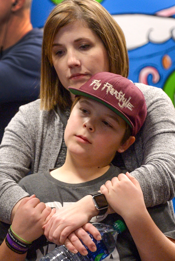 (Leah Hogsten | The Salt Lake Tribune) Amy Johnson, widow of Specialist E4 Geoffrey Johnson, hugs her son, Brayden, 12, at the gate on Saturday. Ten Gold Star families from Salt Lake City were treated to a Winter Wonderland scene, including Whoville and the Grinch at their boarding gate at Salt Lake International Airport, Dec. 7, 2019 before their flight to Disney World aboard the Snowball Express. This month, the Gary Sinise Foundation's Snowball Express will fly more than 1,700 family members of fallen U.S. military heroes to Disney World for a holiday retreat.