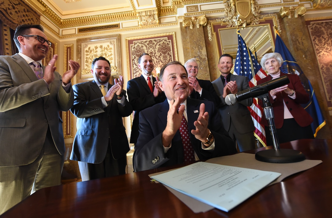 (Francisco Kjolseth  |  The Salt Lake Tribune)  Gov. Gary Herbert, surrounded by state representatives in the Gold Room of the Utah Capitol on Tuesday, March 27, 2018, claps alongside those in attendance after signing H.B. 472 - Medicaid Expansion Revisions, which could provide healthcare to 60,000 Utahns below the poverty line.