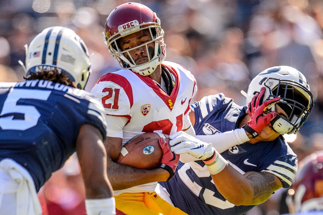 (Trent Nelson  |  The Salt Lake Tribune)  USC Trojans safety Isaiah Pola-Mao (21) knocks the helmet off of Brigham Young Cougars running back Tyler Allgeier after making an interception as BYU hosts USC, NCAA football in Provo on Saturday Sept. 14, 2019.