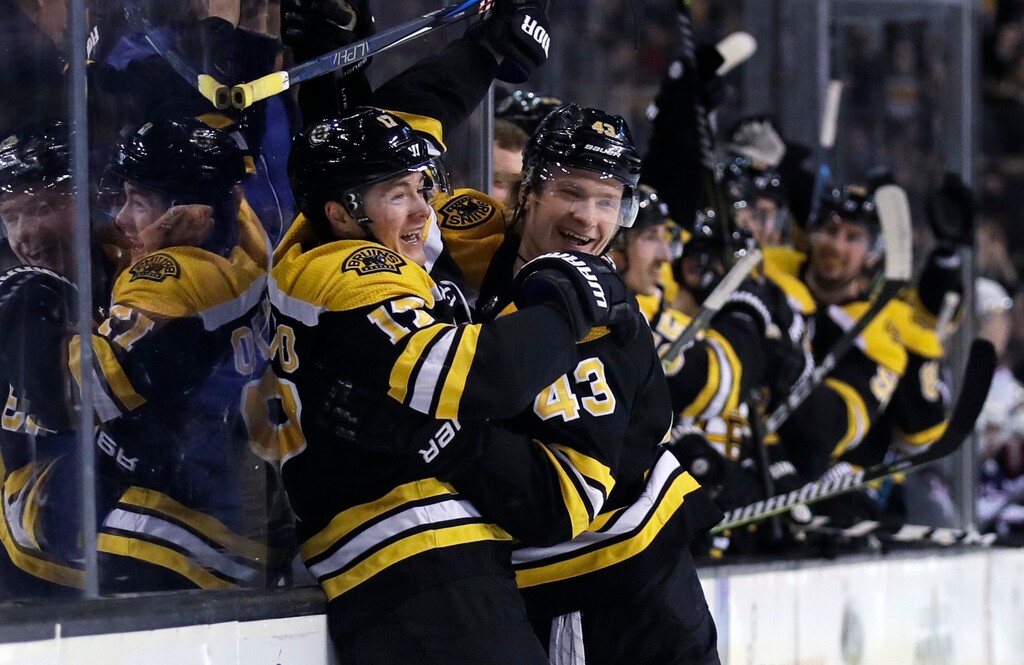 FILE - This March 19, 2018 file photo shows Boston Bruins forward Ryan Donato, left, being congratulated by Danton Heinen (43) after his first goal in his first NHL game, during the second period of a hockey game against the Columbus Blue Jackets in Boston. When Donato was leading the United States in goals and points at the Olympics, dad, former NHL forward and Harvard coach Ted didn’t want to say when the 21-year-old forward would make the jump to the NHL. Turns out it was as soon as Harvard’s season ended as the Bruins signed Donato on Sunday, plugged him in on the second line Monday and watched him record his first goal and assist. (AP Photo/Charles Krupa, file)