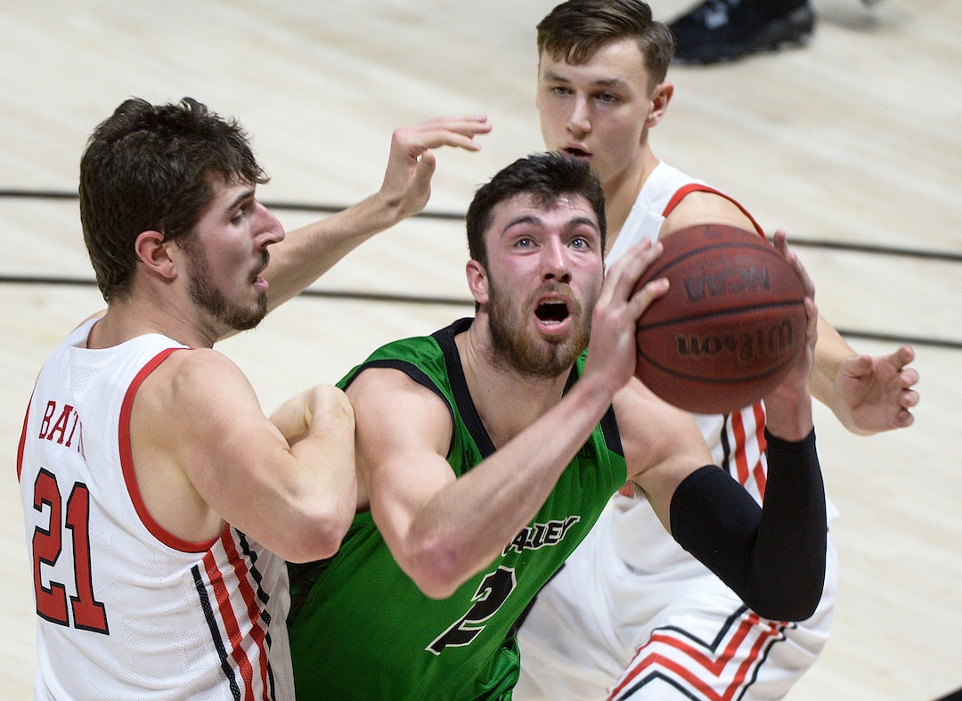 (Leah Hogsten  |  The Salt Lake Tribune) Utah Valley Wolverines forward Evan Cole (2) drives to the net around Utah Utes forward Riley Battin (21) and Utah Utes guard Pelle Larsson (3) as the Utes host Utah Valley University on Tuesday, Dec. 15, 2020 at the Jon M. Huntsman Center.