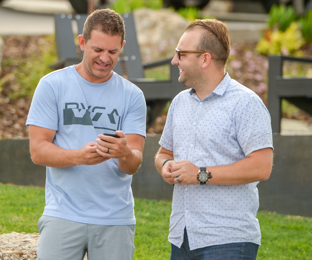 Leah Hogsten  |  The Salt Lake Tribune  l-r  Columbus Court residents Justin Peterson and Dustin Holt watch Peterson's video of the two men jumping into action to battle Tuesday's grass fire in their neighborhood. Five people were injured and one home was damaged by a fast-moving grass fire on Columbus Court, Tuesday, July 24, 2018. Forty homes were evacuated as flames spread through about 100 acres. Between 50 and 60 firefighters responded to the fire.