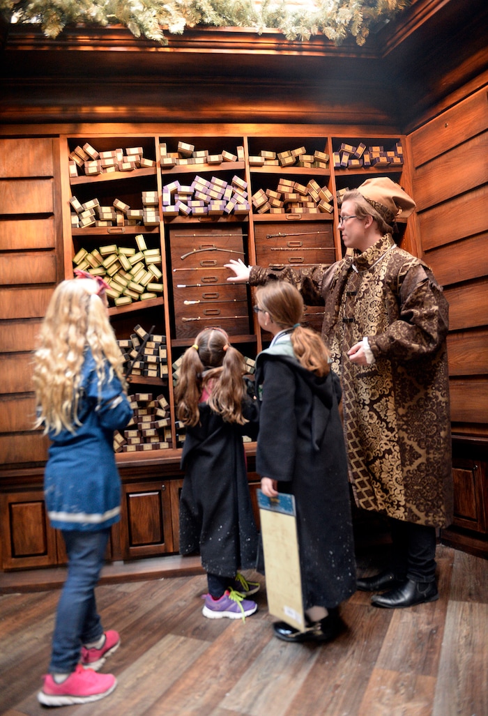 (Al Hartmann  |  The Salt Lake Tribune) 	
Folks get a sneak peek Thursday morning Nov. 9 of Warner Bros. Harry Potter-themed exhibit and shopping area in the Shops at South Town in Sandy. There are interactive activities in addition to "Harry Potter" and "Fantastic Beasts and Where to Find Them" merchandise. Young wizards in robes get shown wands by Deven Skaggs, wand apprentice, right.