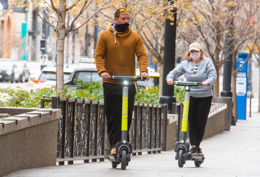 (Rick Egan | Tribune file photo)  Pedestrians wear masks as they ride scooters in downtown Salt Lake City, Tuesday, Nov. 17, 2020.