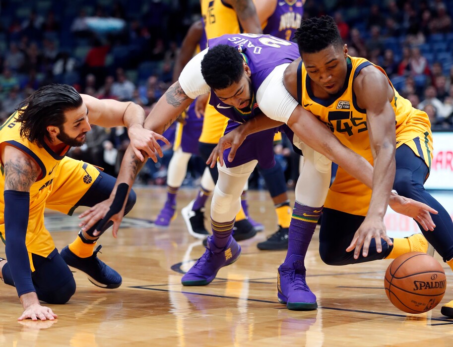 New Orleans Pelicans forward Anthony Davis, center, battles for loose ball between Utah Jazz guard Donovan Mitchell (45) and guard Ricky Rubio in the first half of an NBA basketball game in New Orleans, Monday, Feb. 5, 2018. (AP Photo/Gerald Herbert)