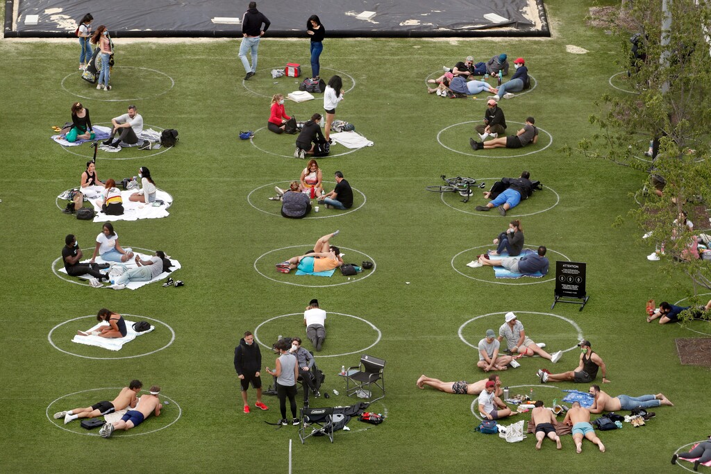 (Kathy Willens | The Associated Press) People relax in marked circles for proper social distancing at Domino Park in the Williamsburg neighborhood of Brooklyn during the current coronavirus outbreak, Sunday, May 17, 2020, in New York.
