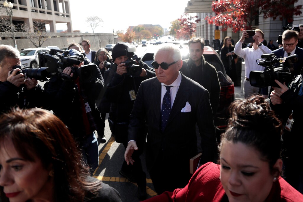 (Julio Cortez | AP) Roger Stone, center, is swarmed by reporters while leaving federal court in Washington, Friday, Nov. 15, 2019. Stone, a longtime friend of President Donald Trump, has been found guilty at his trial in federal court in Washington.