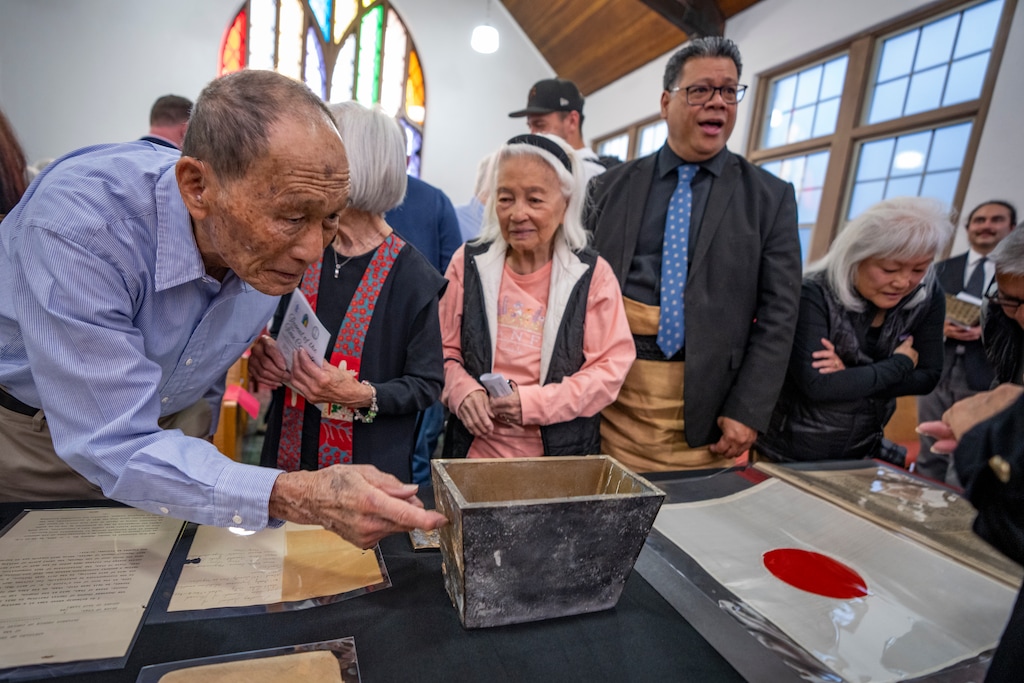 (Rick Egan | The Salt Lake Tribune) Curious onlookers examine the contents of a time capsule from 1924 at the Japanese Church of Christ on Saturday, Nov. 1, 2025.

