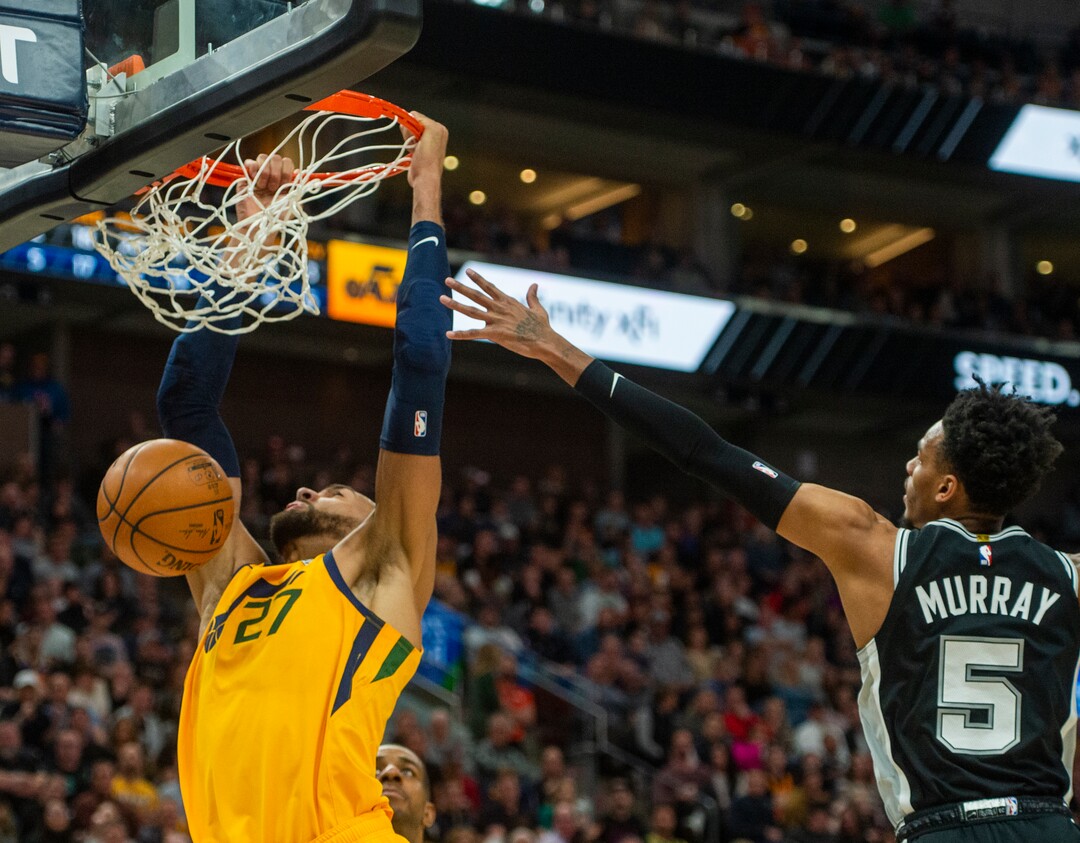 (Rick Egan  |  The Salt Lake Tribune)    Utah center Rudy Gobert (27) gets past San Antonio Spurs guard Dejounte Murray (5) to score for the Jazz, in NBA action between the Utah Jazz and the San Antonio Spurs, in Salt Lake City, Friday, Feb. 21, 2020.