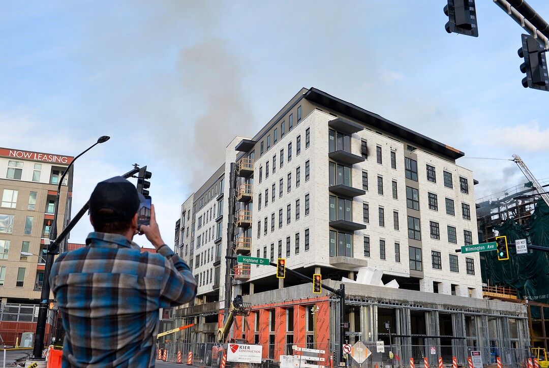 (Chris Samuels | The Salt Lake Tribune) Onlookers watch as emergency crews continue to respond to a four-alarm fire in a new construction of apartment residences in Sugar House, Wednesday, Oct. 26, 2022.