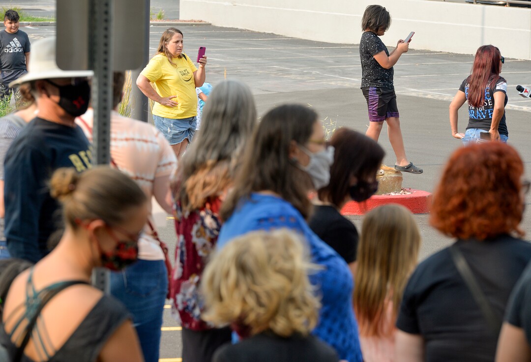 (Chris Samuels | The Salt Lake Tribune) A woman wearing a "see my smile" t-shirt, which protests face coverings, watches a rally advocating mask use in schools outside the Utah Board of Education building, Friday, Aug. 6, 2021.