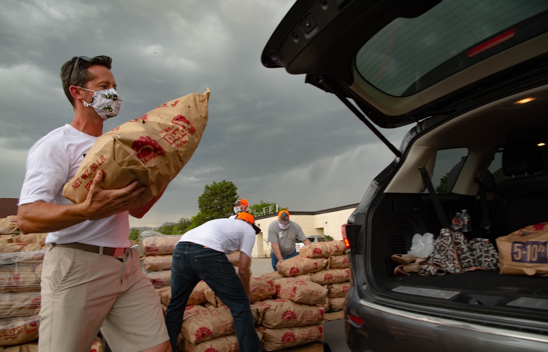 (Francisco Kjolseth  |  The Salt Lake Tribune) Jared Smith loads 50-pound bags of potatoes in people’s trunks as the third “Miracle Project” for the nonprofit foundation which raises money to purchase food produced by Utah farmers and then gives to residents in need, takes place at the Utah State Fairpark in Salt Lake City on Monday, July 27, 2020. The food donation from the Utah Farm Bureau’s “Farmers Feeding Utah” program provided food for 600 individuals and families who have recently become unemployed due to the coronavirus.