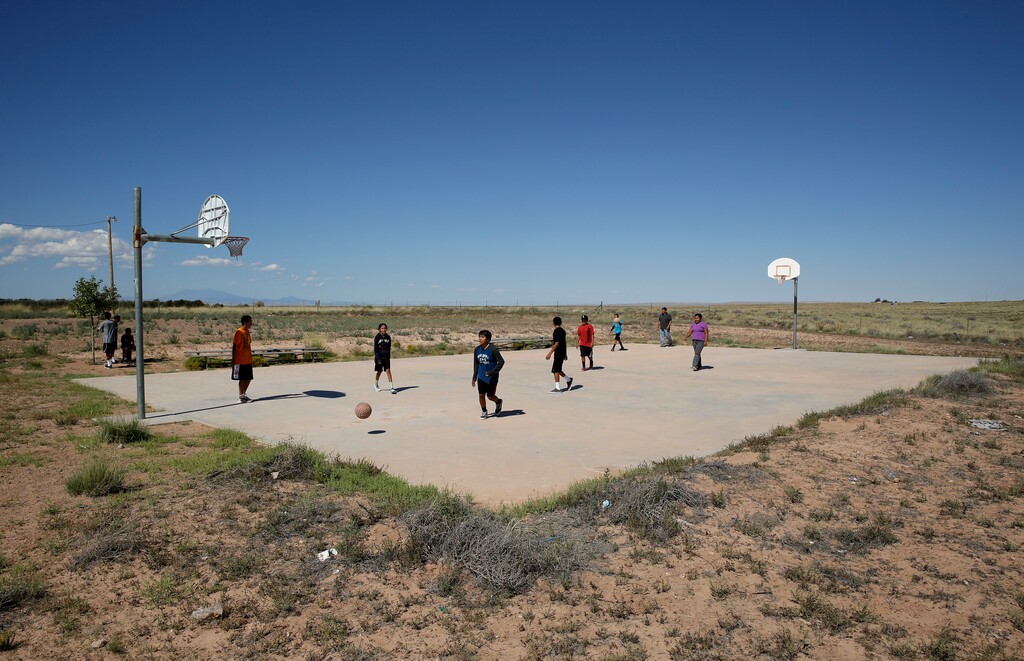 (John Locher | AP file photo) Students play basketball at Little Singer Community School in Birdsprings, Ariz., on the Navajo Nation in September 2014. Basketball is woven in the fabric of Native American life. Now, during a global pandemic, the balls have all but stopped bouncing. Already hit hard by the coronavirus outbreak, Native Americans are faced with life without basketball — or any other sport — for the foreseeable future.