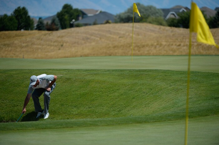 (Francisco Kjolseth  |  The Salt Lake Tribune)  Trenton Twamley of Murrieta, CA, rakes the sand trap following a frustrating finish on his first nine as he joins a mixture of local pros and nationwide travelers making their annual attempt to qualifying for the Utah Championship on the Web.com Tour and a shot to play in a PGA Tour-brand event at Talons Cove Golf Course in Saratoga Springs on Monday, July 7, 2018. Only 12 players advance from a field of roughly 140.