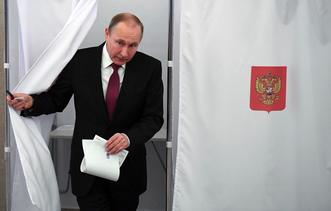 Russian President and Presidential candidate Vladimir Putin exits a polling booth as he prepares to cast his ballot during Russia's presidential election in Moscow, Russia, Sunday, March 18, 2018. Putin's victory in Russia's presidential election Sunday isn't in doubt. The only real question is whether voters will turn out in big enough numbers to hand him a convincing mandate for his fourth term — and many Russian workers are facing intense pressure to do so. (Yuri Kadobnov/Pool Photo via AP)