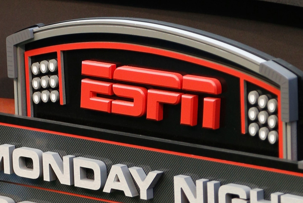 FILE - This Sept. 16, 2013, file photo shows the ESPN logo prior to an NFL football game between the Cincinnati Bengals and the Pittsburgh Steelers, in Cincinnati.  ESPN says it is eliminating 150 studio and production employees as the sports broadcasting giant continues to shift its focus to a more digital future. The company says the layoffs, which were announced Wednesday morning, Nov. 29, 2017, in a memo to employees, don't include on-air talent and will have a minimal impact on the network's signature SportsCenter news program. (AP Photo/David Kohl, File)