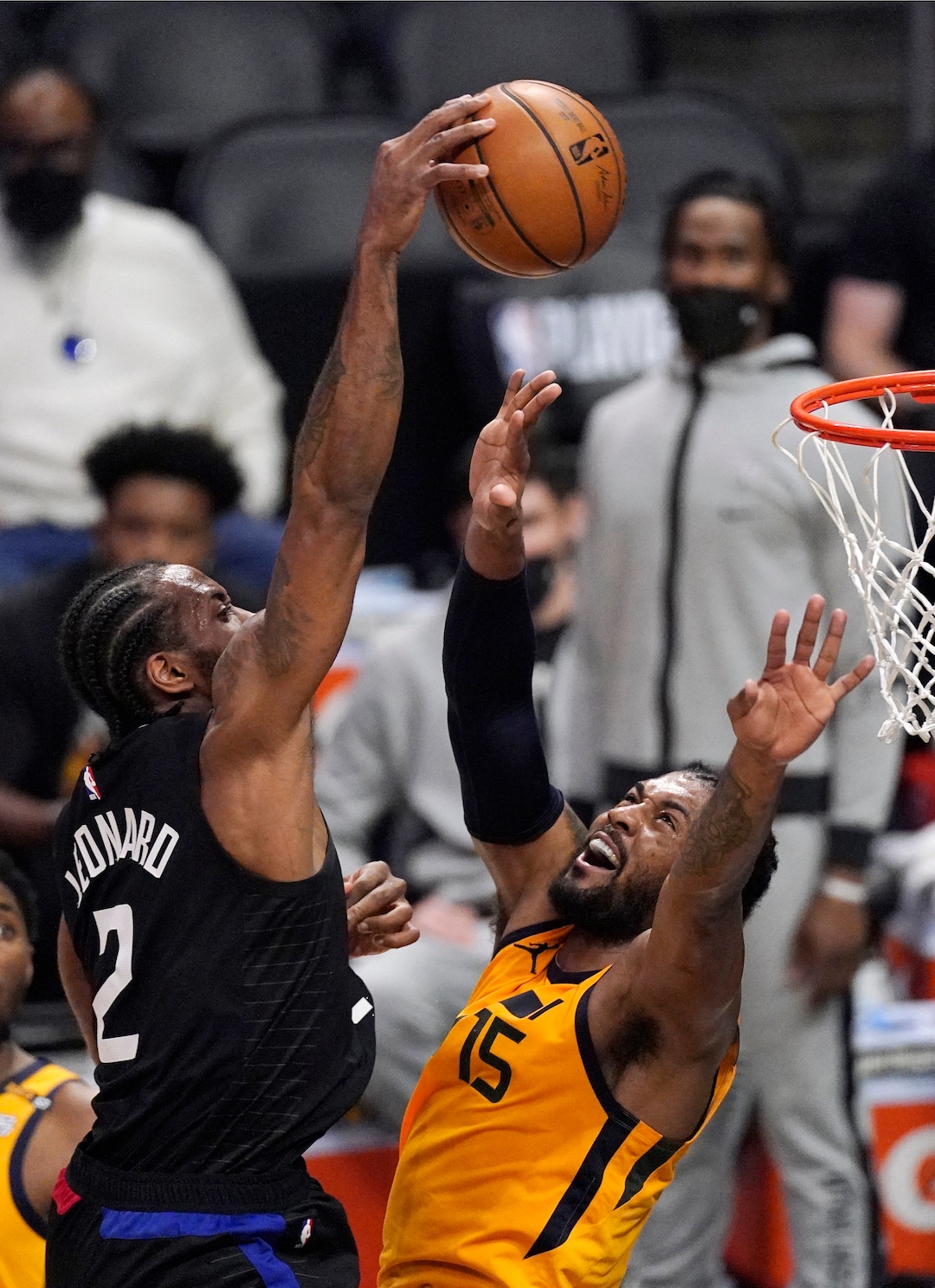 Los Angeles Clippers forward Kawhi Leonard, left, dunks over Utah Jazz center Derrick Favors during the first half in Game 4 of a second-round NBA basketball playoff series Monday, June 14, 2021, in Los Angeles. (AP Photo/Mark J. Terrill)