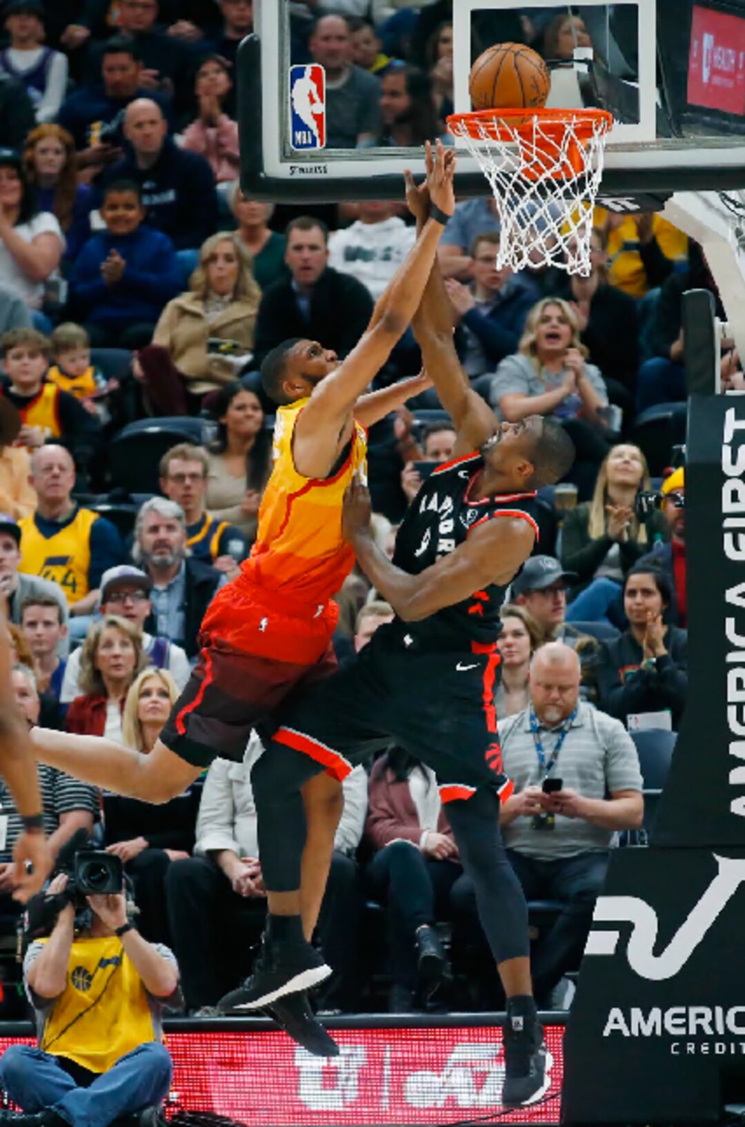 Utah Jazz center Tony Bradley, left, scores against Toronto Raptors center Serge Ibaka (9) in the first half during an NBA basketball game Monday, March 9, 2020, in Salt Lake City. (AP Photo/Rick Bowmer)