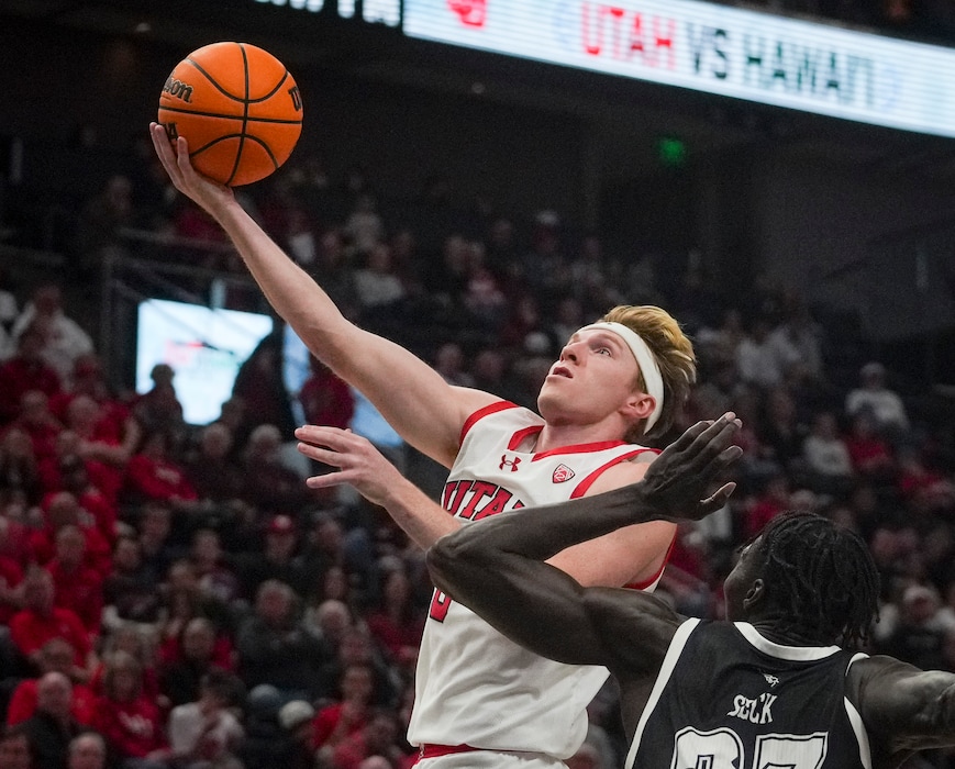 (Bethany Baker  |  The Salt Lake Tribune) Utah Utes guard Hunter Erickson (0) goes for a lay up as Hawaii Warriors center Mor Seck (23) defends at the Delta Center in Salt Lake City on Thursday, Nov. 30, 2023.