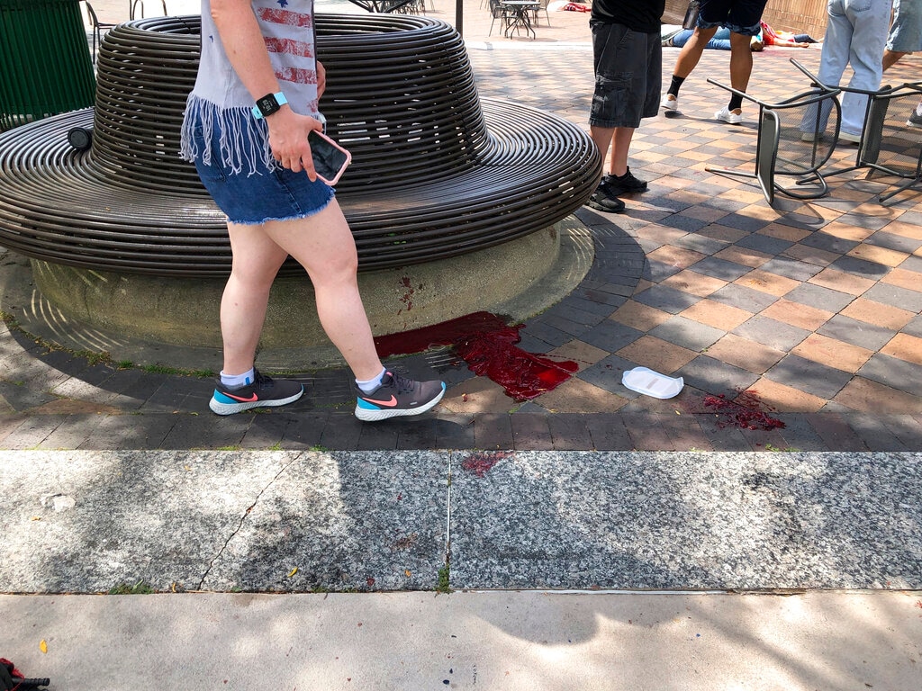 (Lynn Sweet/Chicago Sun-Times via AP) Blood pooled at Port Clinton Square in Highland Park, after a shooting at a July Fourth parade, in a Chicago suburb, Monday, July 4, 2022.