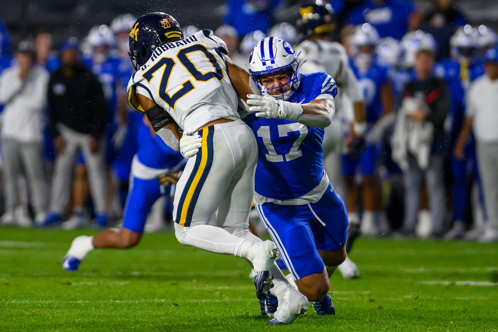 BYU linebacker Jack Kelly, right, tackles West Virginia running back Diore Hubbard during a game on Oct. 3, 2025, in Provo, Utah. Kelly was selected by the New York Giants in the sixth round of the NFL Draft on Saturday. (AP Photo/Tyler Tate)
