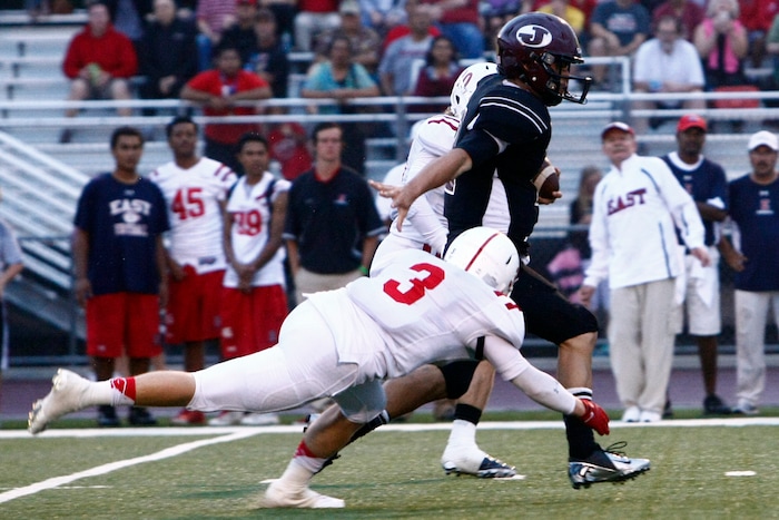 (Chris Detrick  |  The Salt Lake Tribune)  Jordan's Austin Kafentzis (2) runs past East's Jager Chynoweth (3) during the game at Jordan High School Friday September 6, 2013. East is winning the game 59-30 in the third quarter.