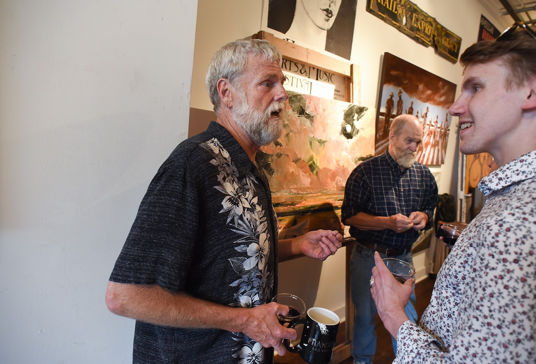 (Francisco Kjolseth  |  The Salt Lake Tribune)  Artists Thomas Elmo Williams, left, and his partner David Richey Johnsen, in background, speak with visitors, including James Stolhand, from Rose Park during Helper's First Fridays. The monthly gallery stroll draws visitors to historic Main Street the first Friday of every month.