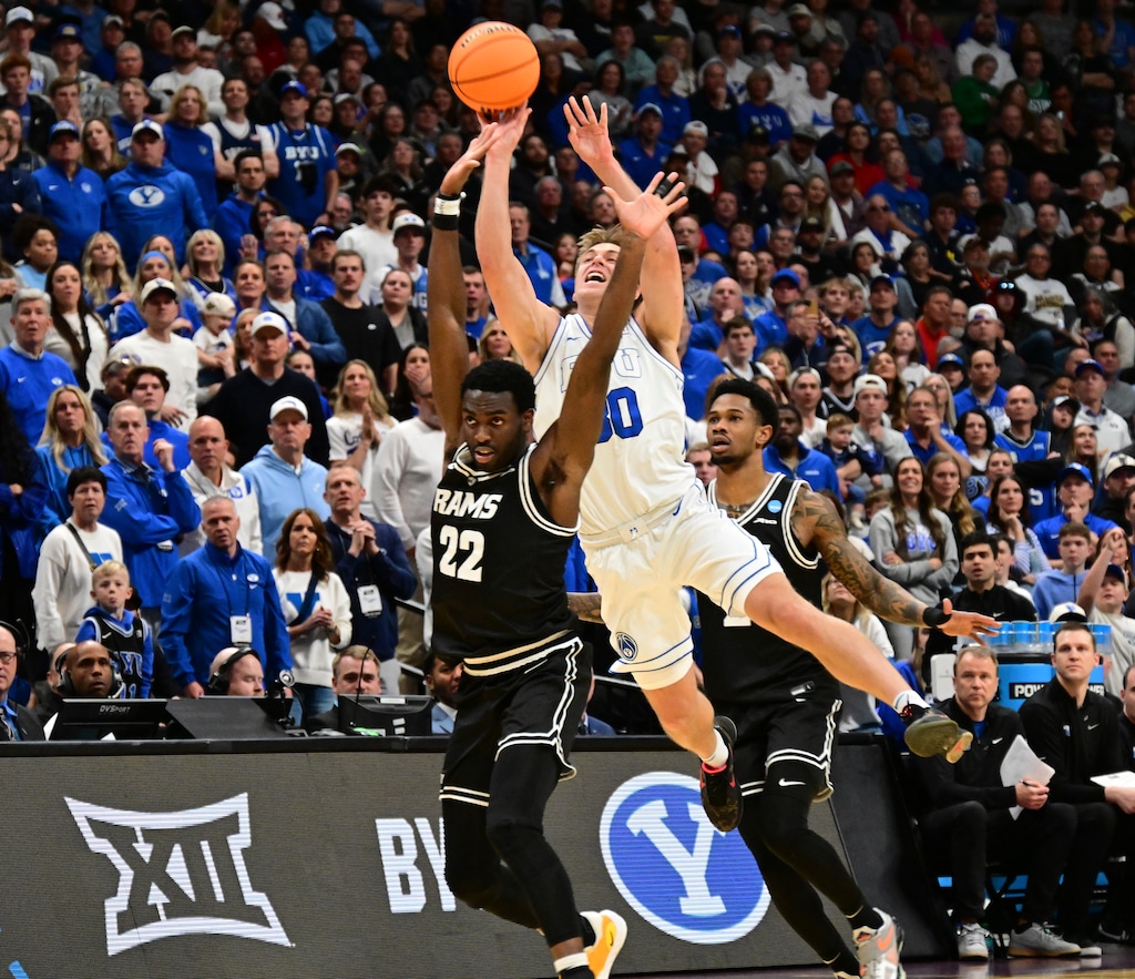 (John Leyba | AP) BYU guard Dallin Hall, back, shoots over Virginia Commonwealth guard Joe Bamisile during the first half in the first round of the NCAA college basketball tournament Thursday, March 20, 2025, in Denver.