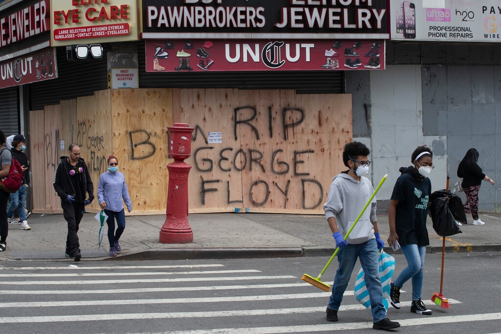 (Mark Lennihan | AP photo)

Volunteers Christian Tyler and Ashante West, right, carry brooms after participating in a community cleanup effort as they walk by a boarded up pawnbroker's store, Tuesday, June 2, 2020, in the Fordham Road area of the Bronx borough of New York. Protesters broke into stores Monday night in reaction to George Floyd's death while in police custody on May 25 in Minneapolis.